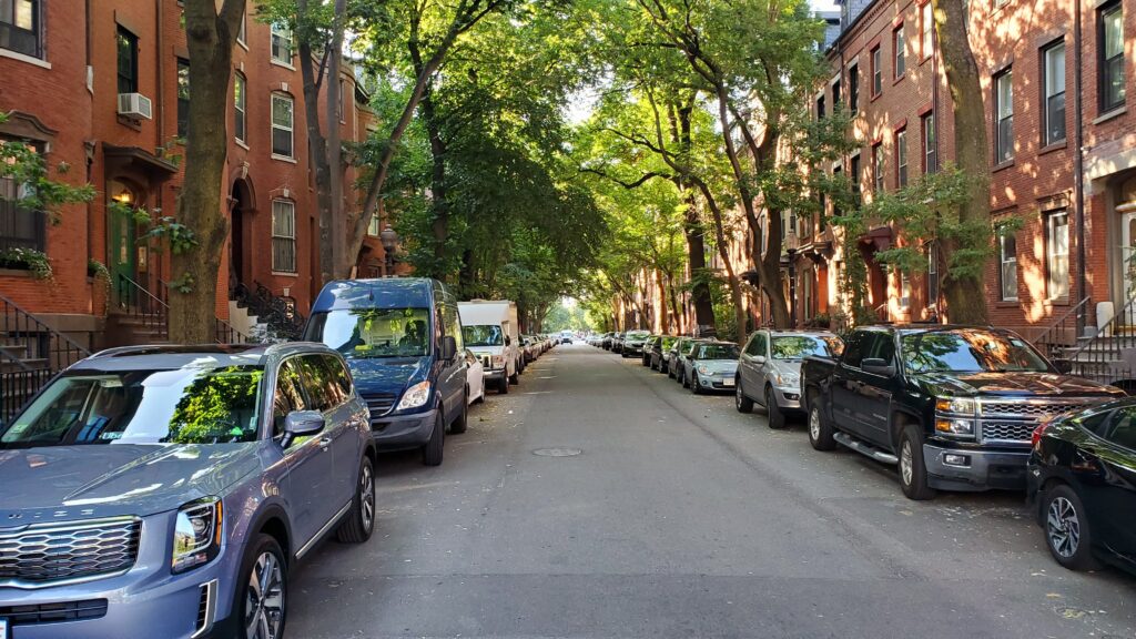 green street full of cars with red buildings